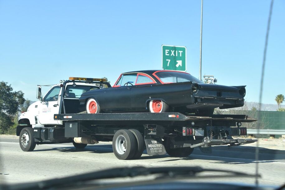 Retro car being towed on flatbed Knightdale Towing tow truck